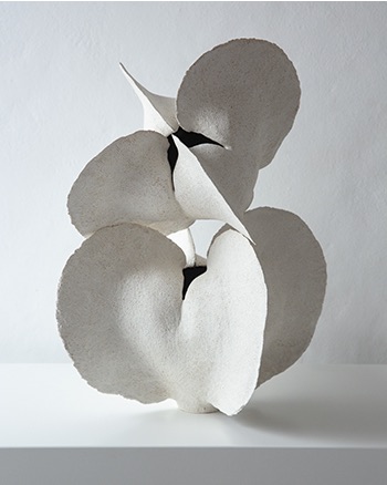 Stacked white ceramic flower-like form on a plinth