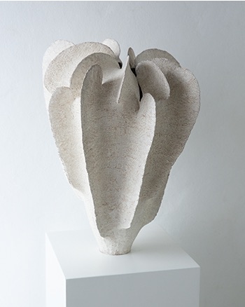 Tall white ceramic vessel with layered pod-like sides