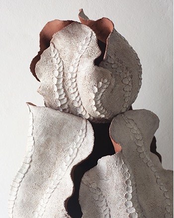 Close detail of textured white ceramic surface with terracotta clay edge