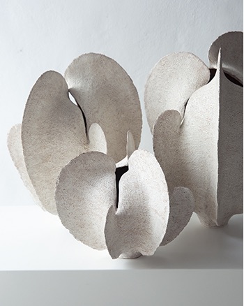 Group of white pod-like ceramic forms with soft textured surfaces