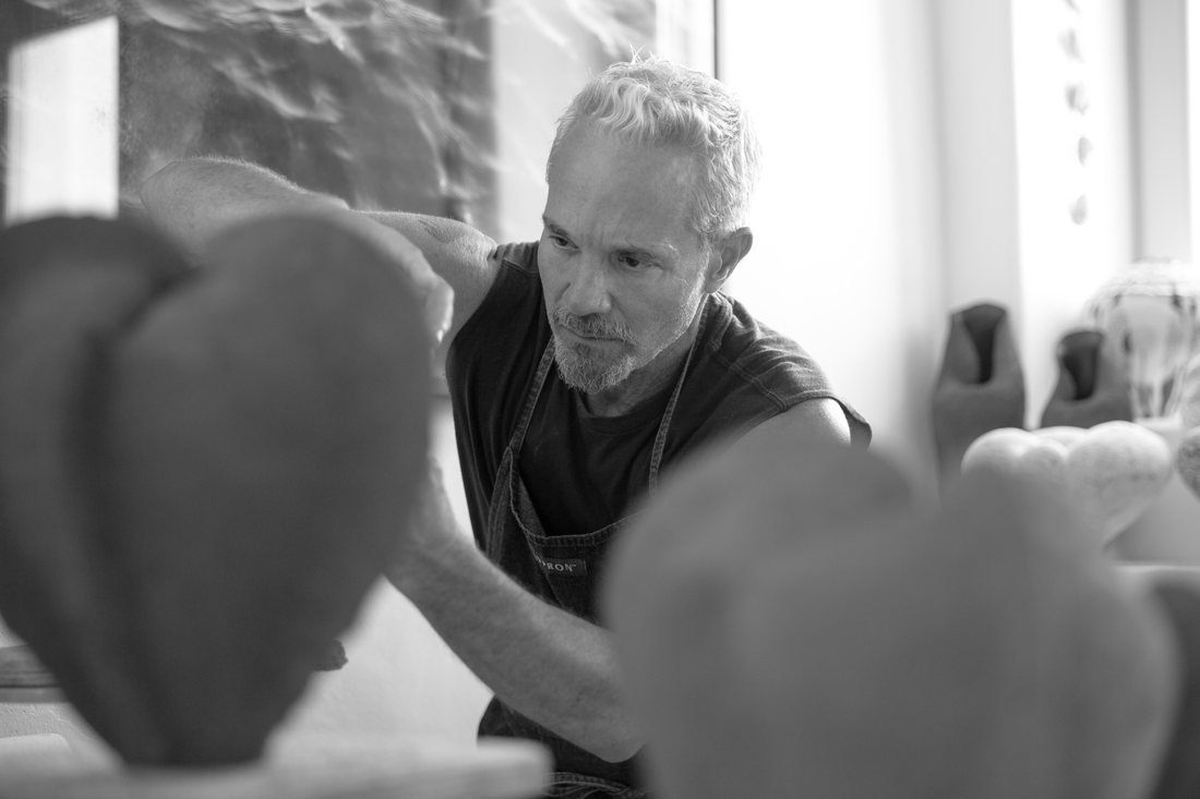 Ceramic artist Todd Marshard working among sculptural ceramic forms in his Lefkes, Paros studio