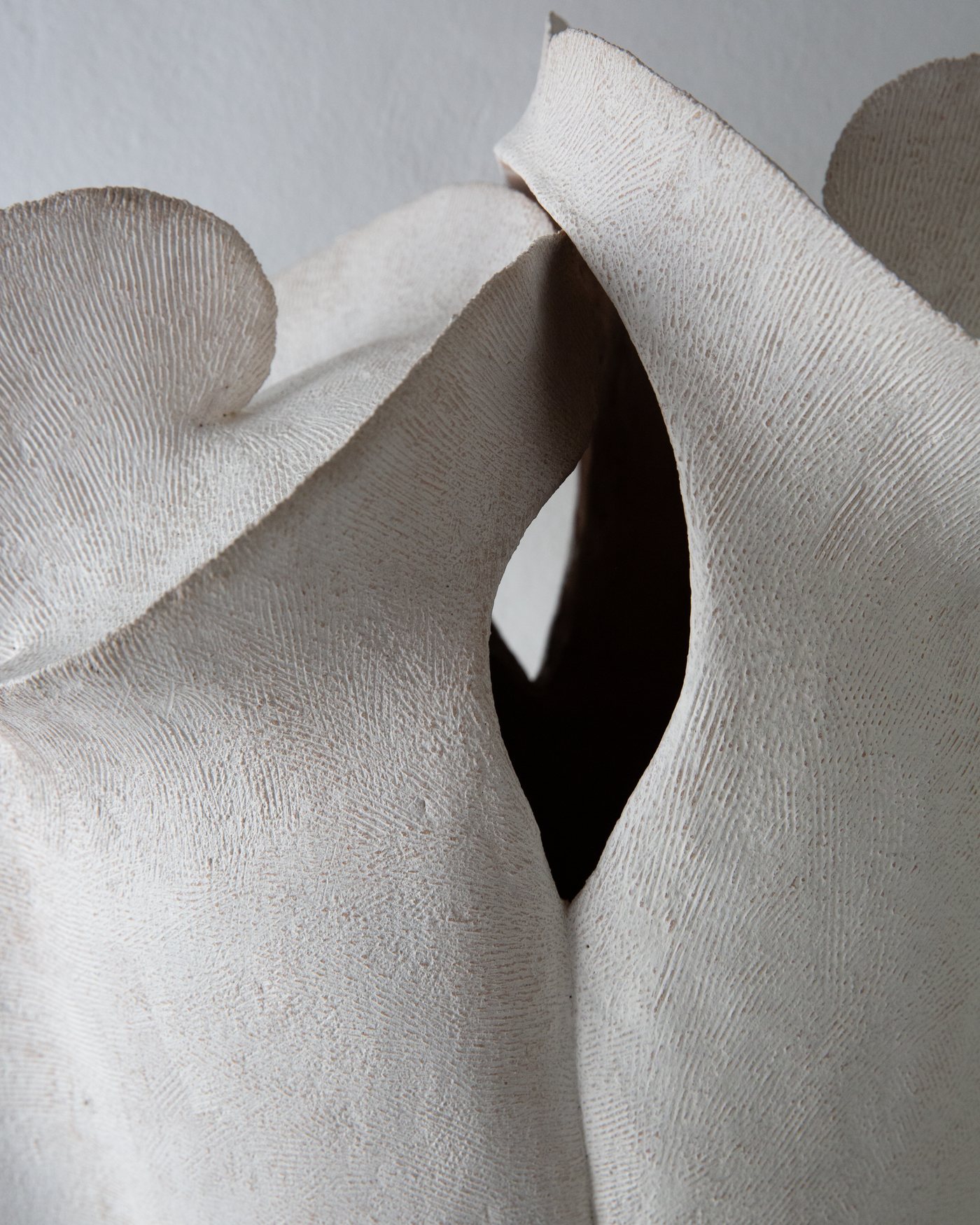 Close view into a white textured ceramic vessel opening